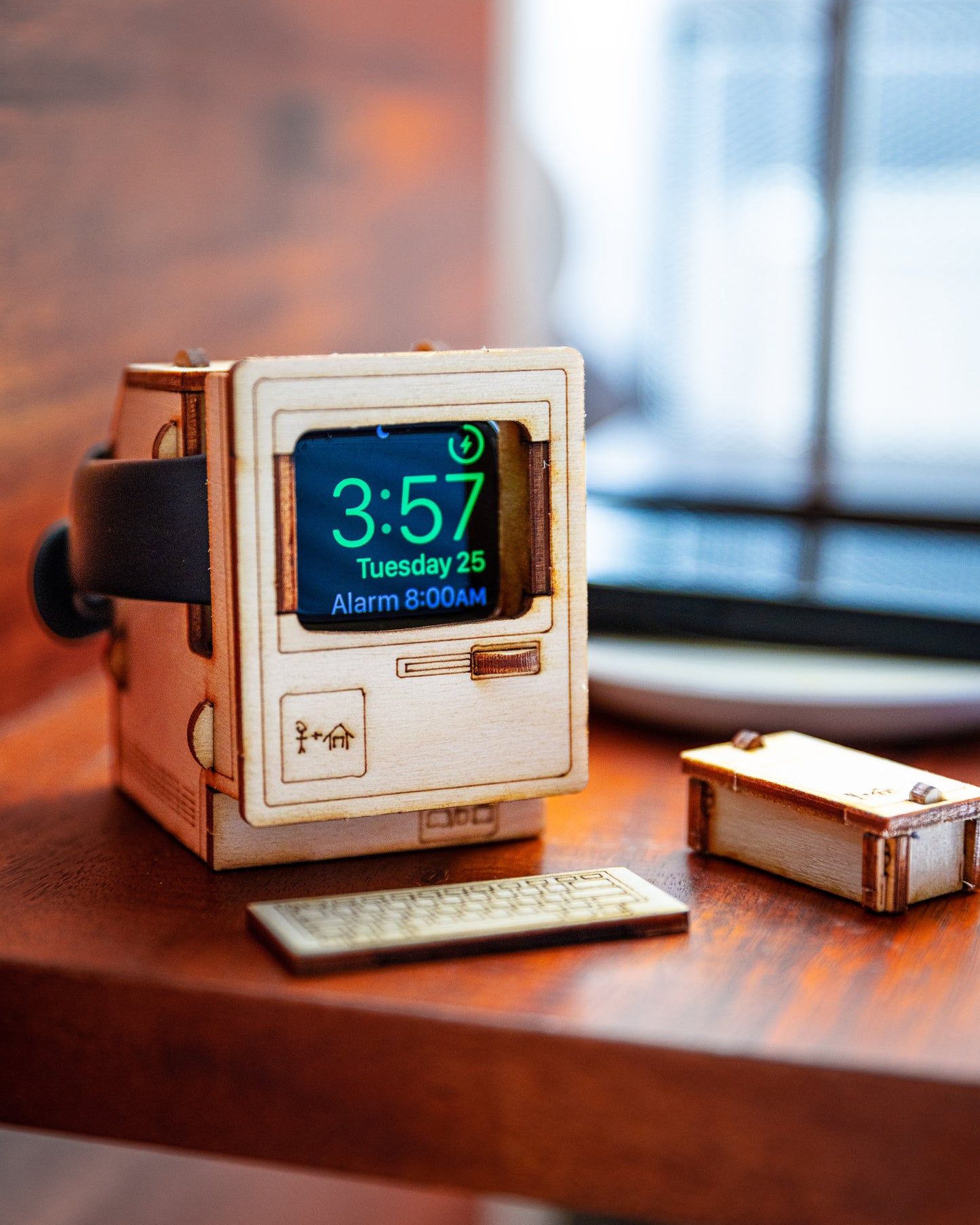 A wooden vintage computer watch charger stand with a slot for a smartwatch, assembled and placed on a wooden nightstand.