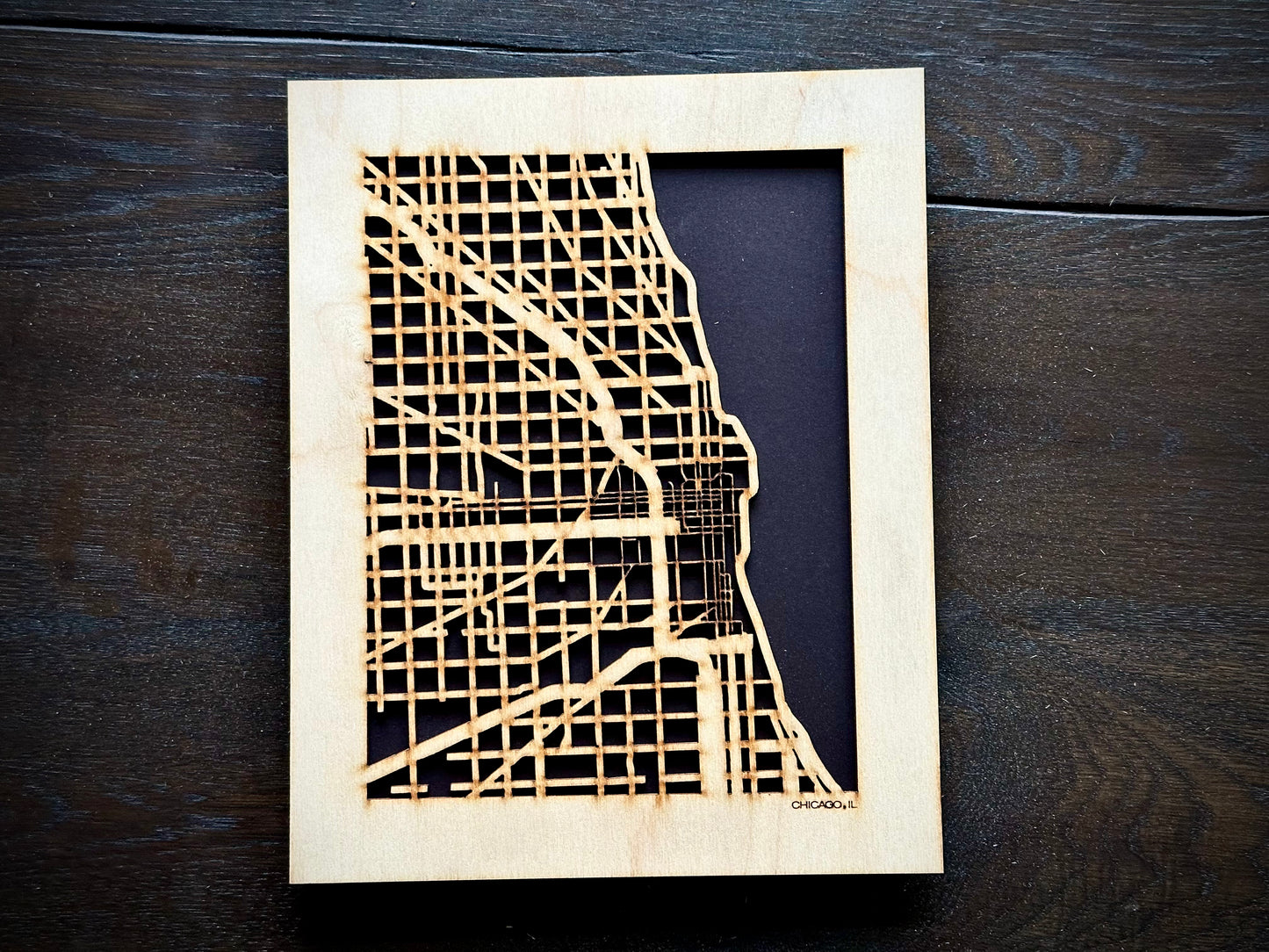 Wooden cutout of the city of Chicago on a dark wooden surface