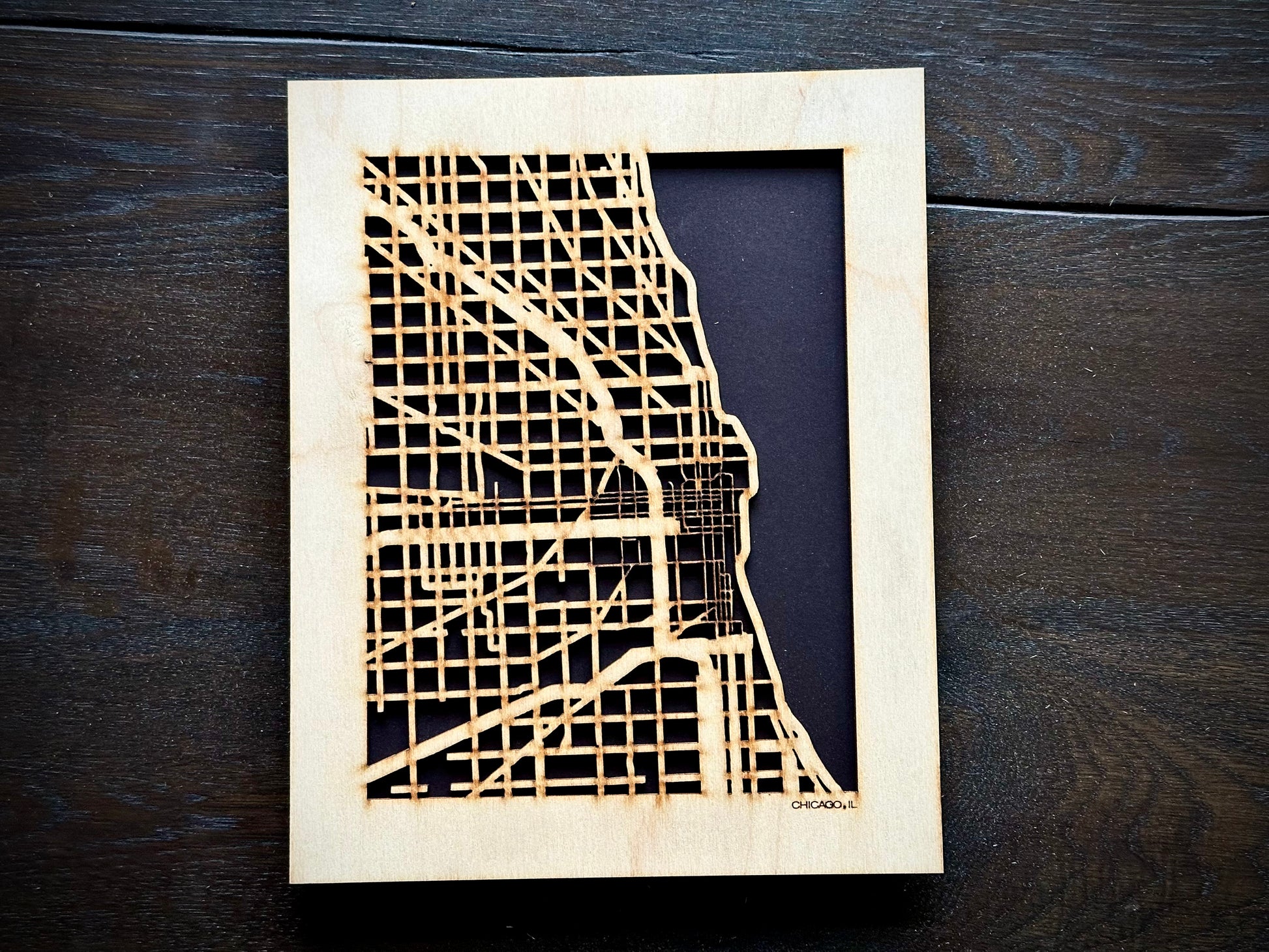 Wooden cutout of the city of Chicago on a dark wooden surface
