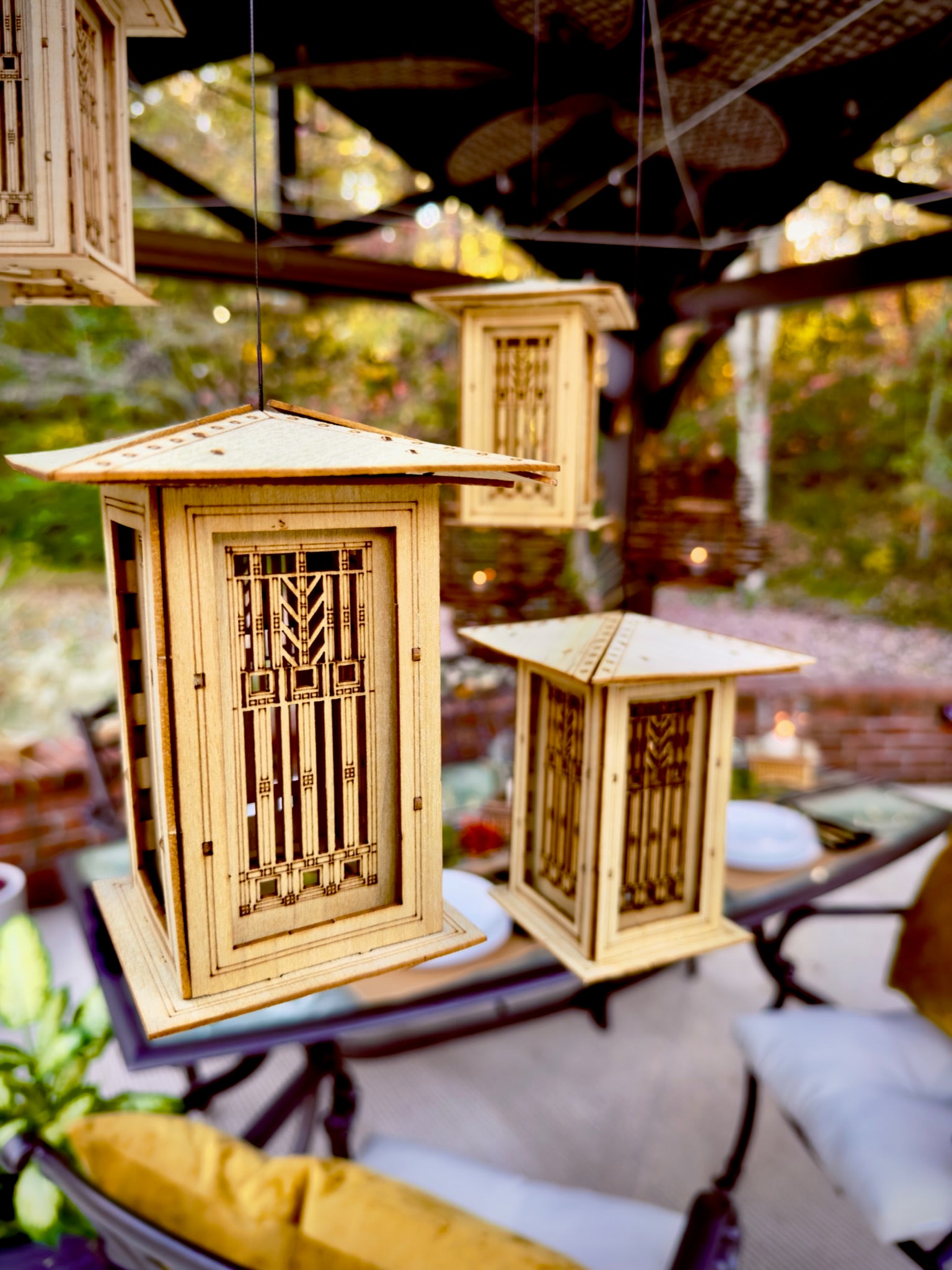 Multiple hanging Prairie style lanterns displayed together in an outdoor entertaining area