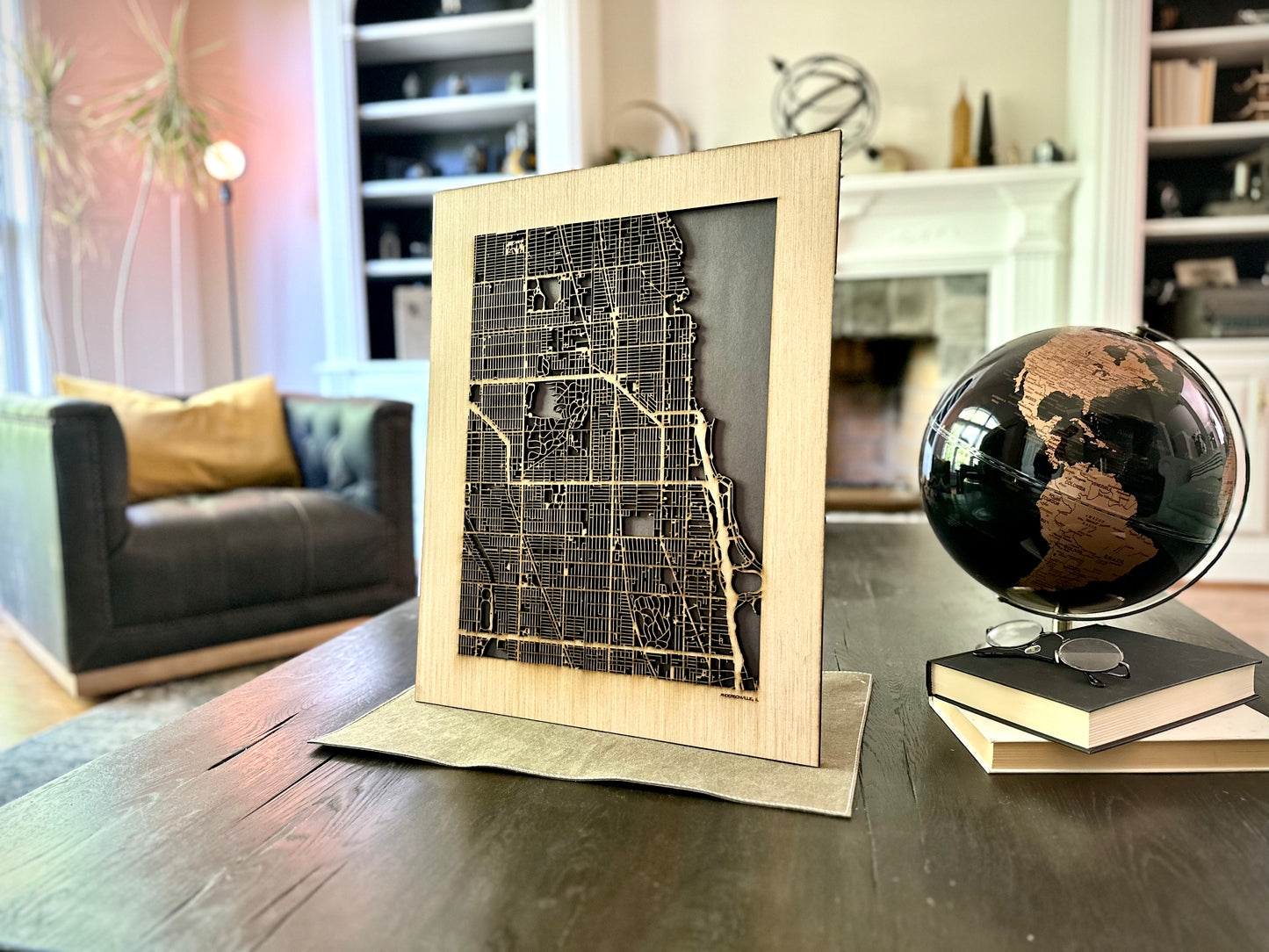 Framed city map on a table with a globe in a living room setting