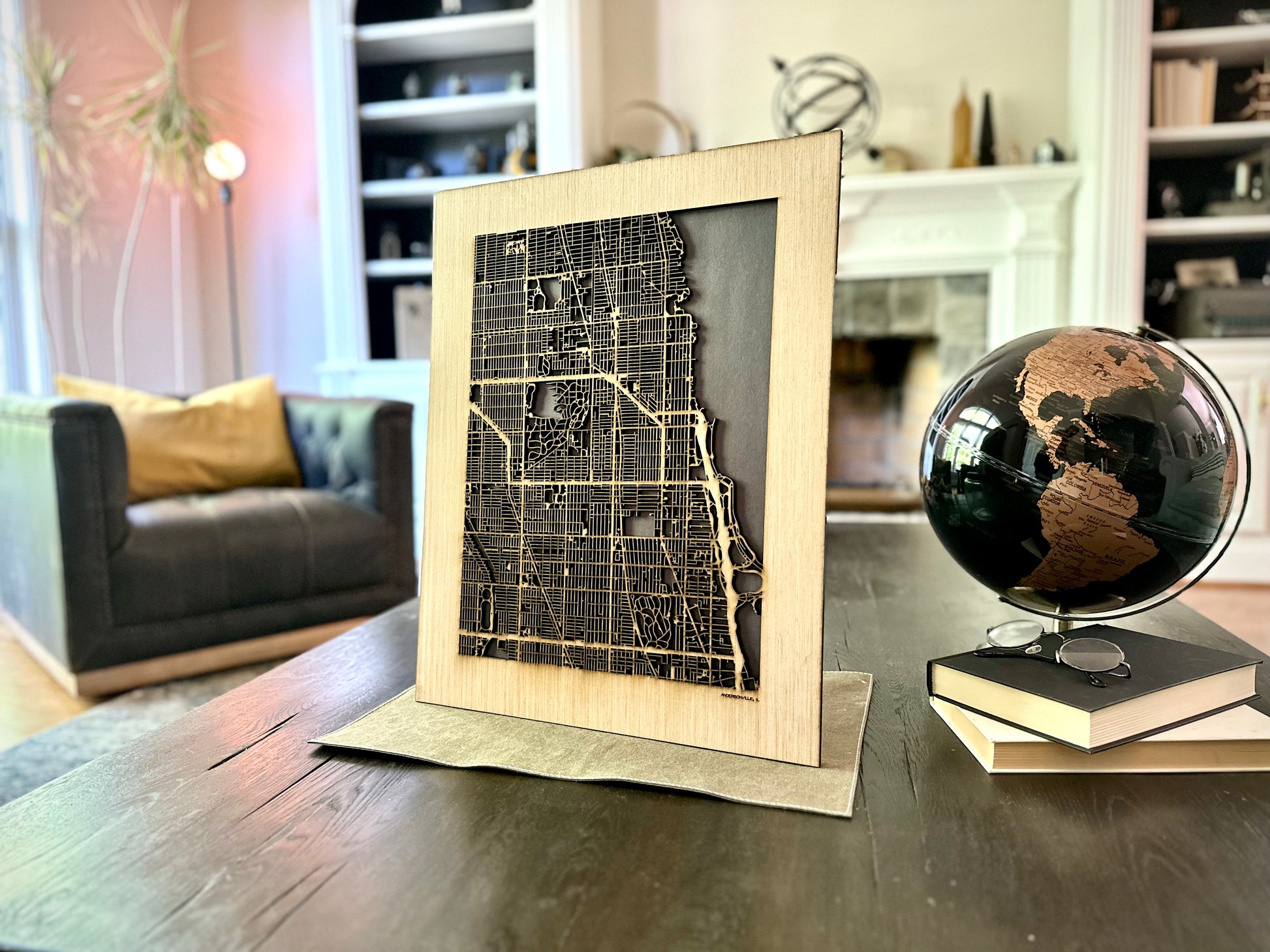 Framed city map on a table with a globe in a living room setting