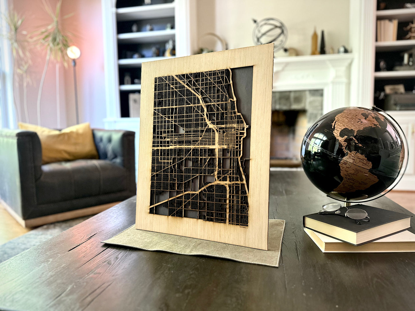 Wooden map cut out on a table with a globe in a living room setting