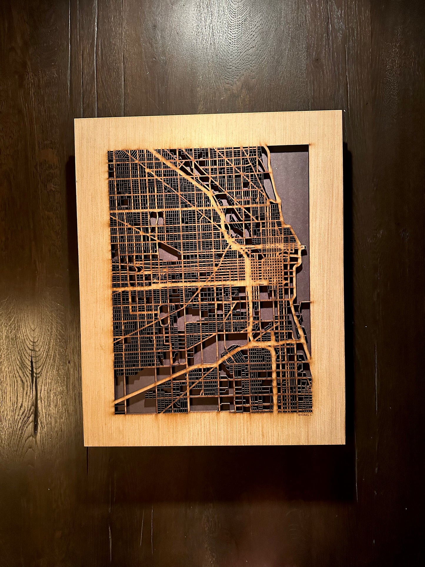 Wooden framed map of a city on a dark wooden background
