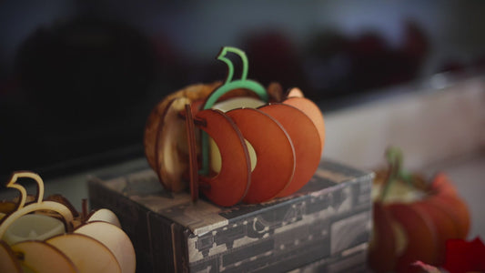 Video showcasing miniature wooden pumpkin decorations in orange and natural wood finishes arranged with fall decor