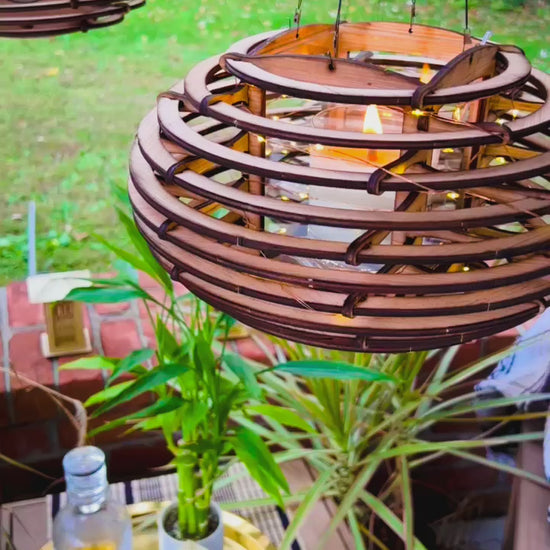 video of hanging Nest lantern swaying gently in daylight, showcasing its nature-inspired design and warm ambient glow