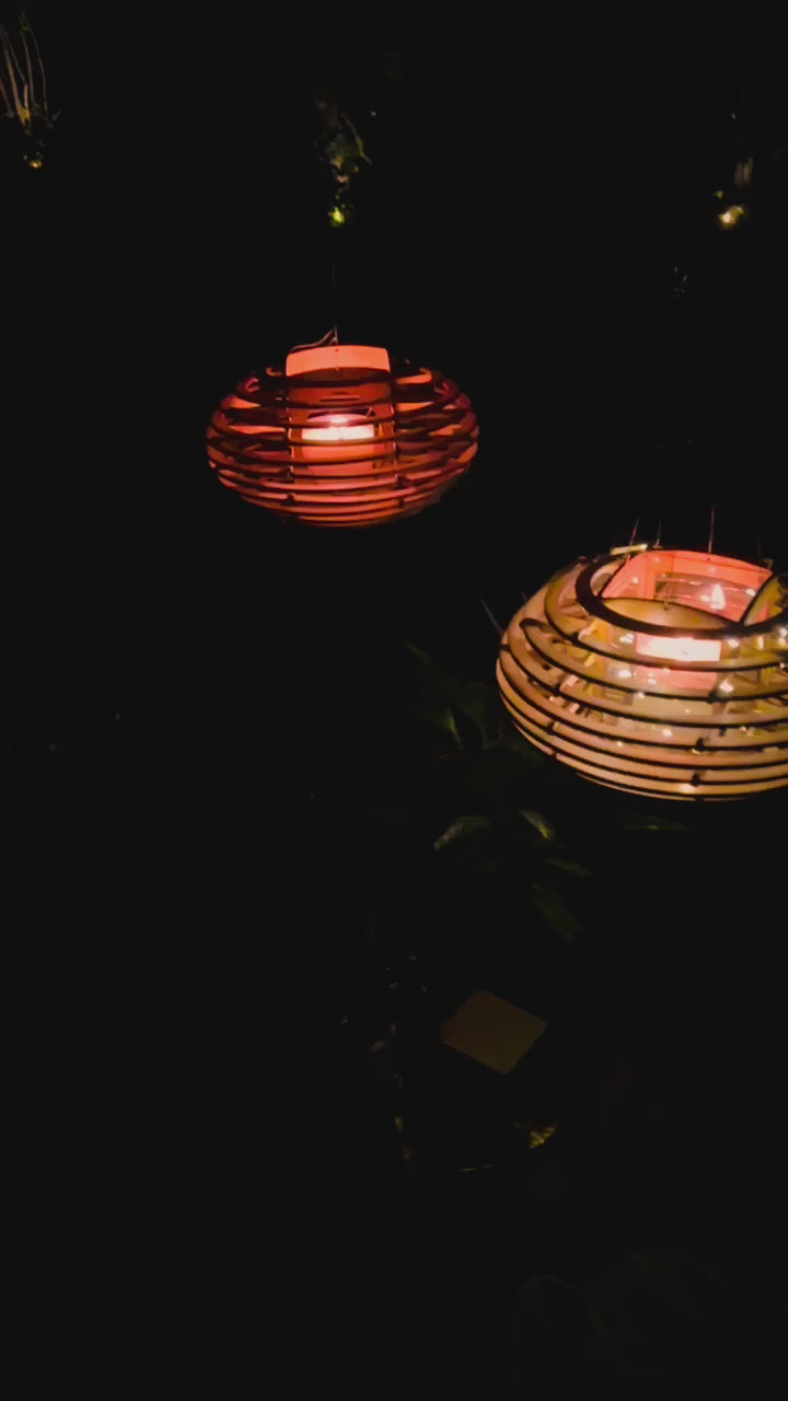 video of illuminated Nest lanterns hanging outdoors at night, creating a warm and relaxing atmosphere