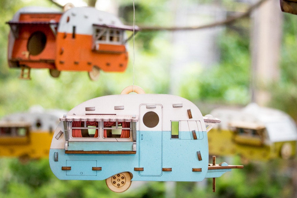 Vintage camper birdhouse DIY wooden kit hanging outdoors with painted retro trailer design