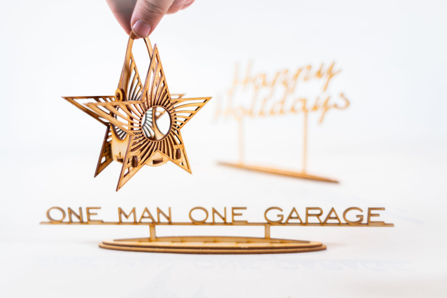 hand holding assembled wooden star tealight lantern showing hanging loop and geometric construction