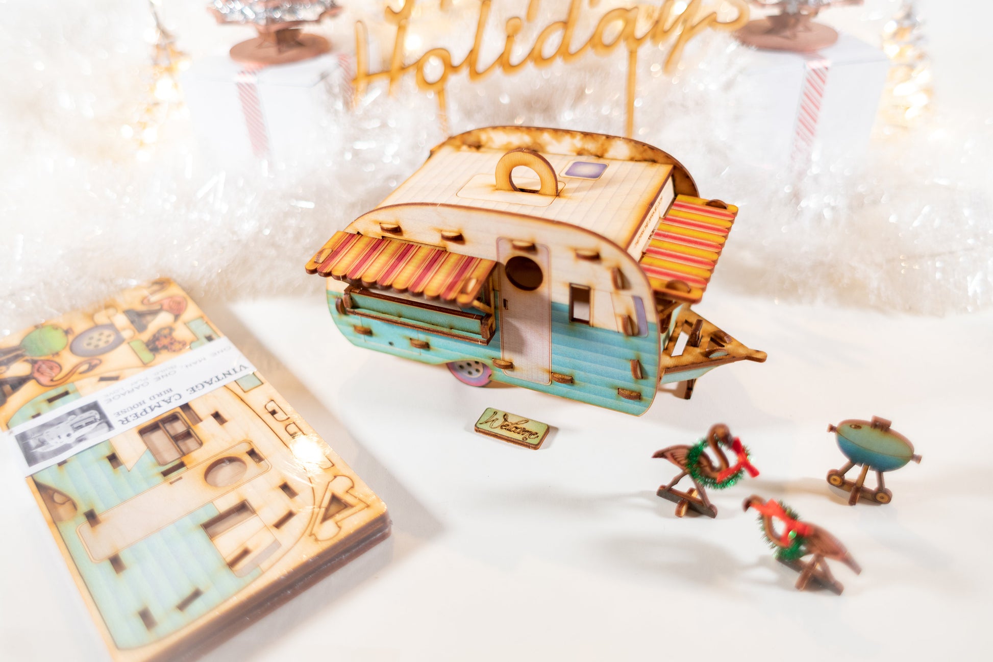 DIY camper birdhouse kit displayed with packaging and small accessories on Happy Holidays styled tabletop