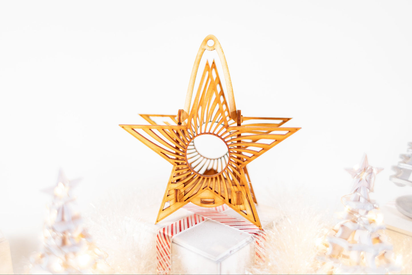 star-shaped hanging candle luminaire with layered laser-cut wood design on bright background