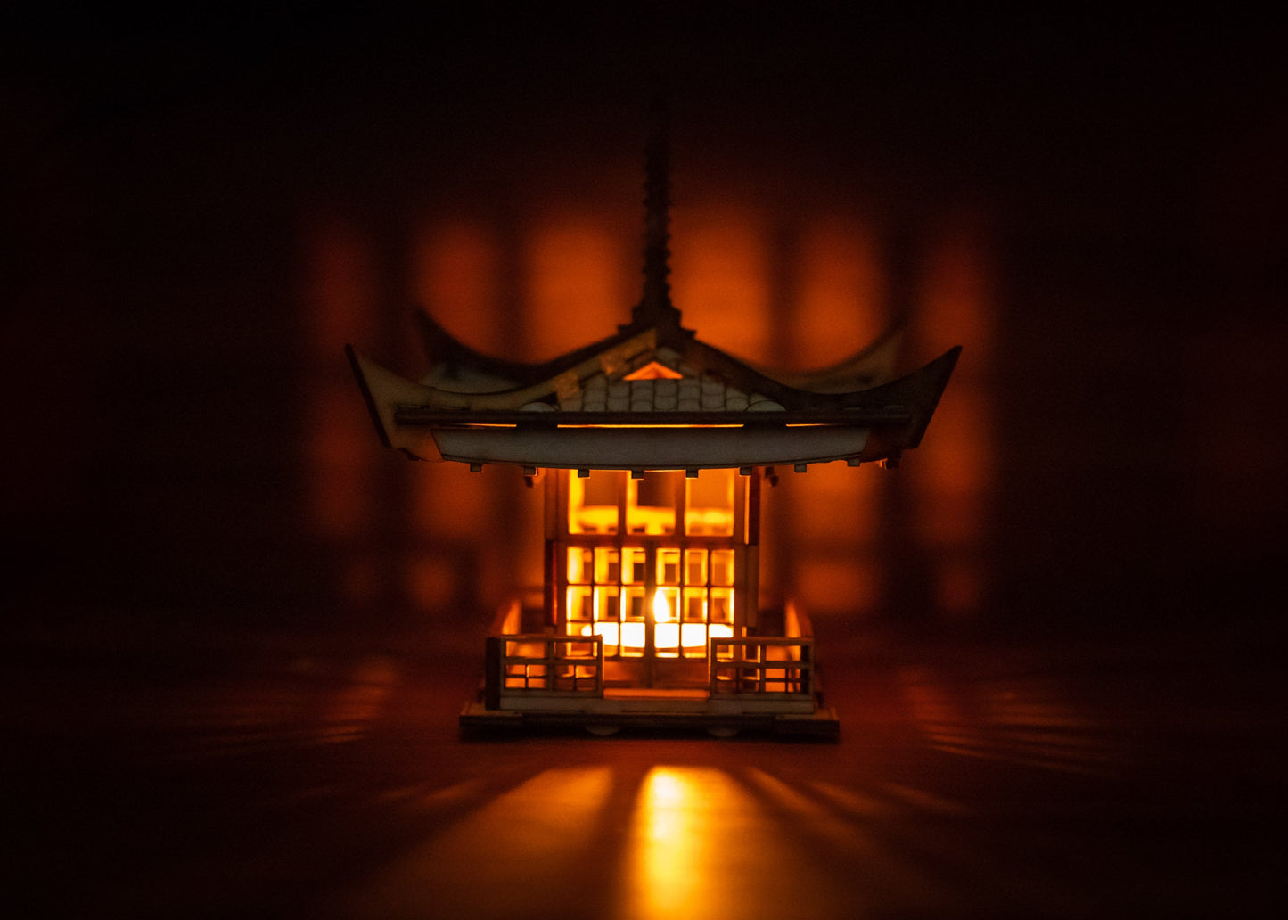 Front view of illuminated wood lantern creating warm ambient lighting in dark setting