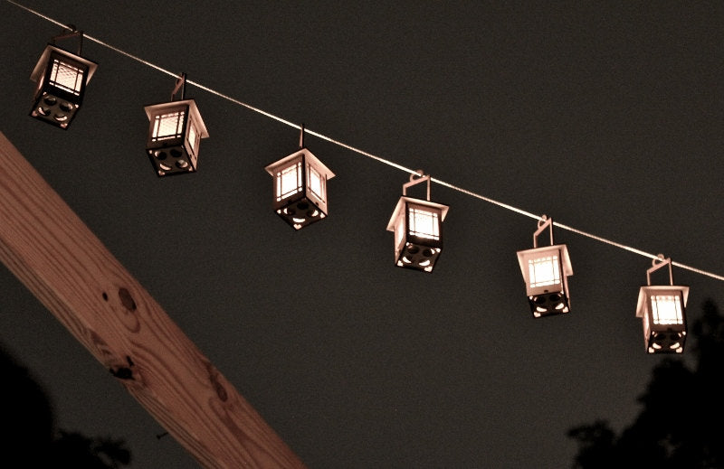 hanging bungalow lantern luminaires suspended on a string creating decorative outdoor lighting